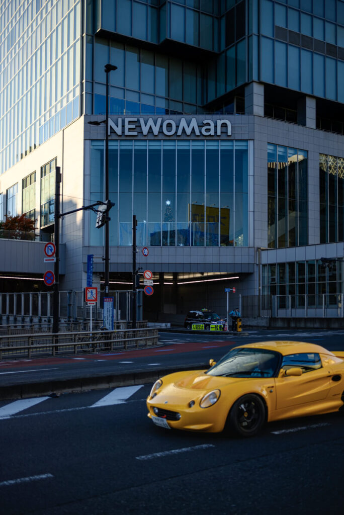 新宿バスタ前を走る黄色いスポーツカー